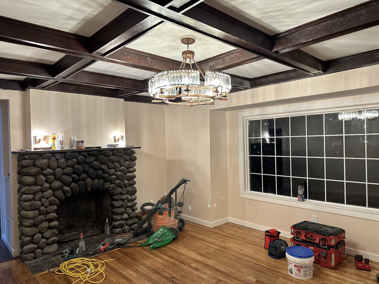 Chandelier installed under a coffered ceiling by Pika Electrical